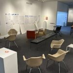 room with chairs, a pedestal, taped pages on the wall