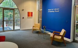 photograph of a blue wall and chairs, wall text reads "Dana Art Library and Reading Room"