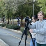 Two students with a camera and tripod on church street